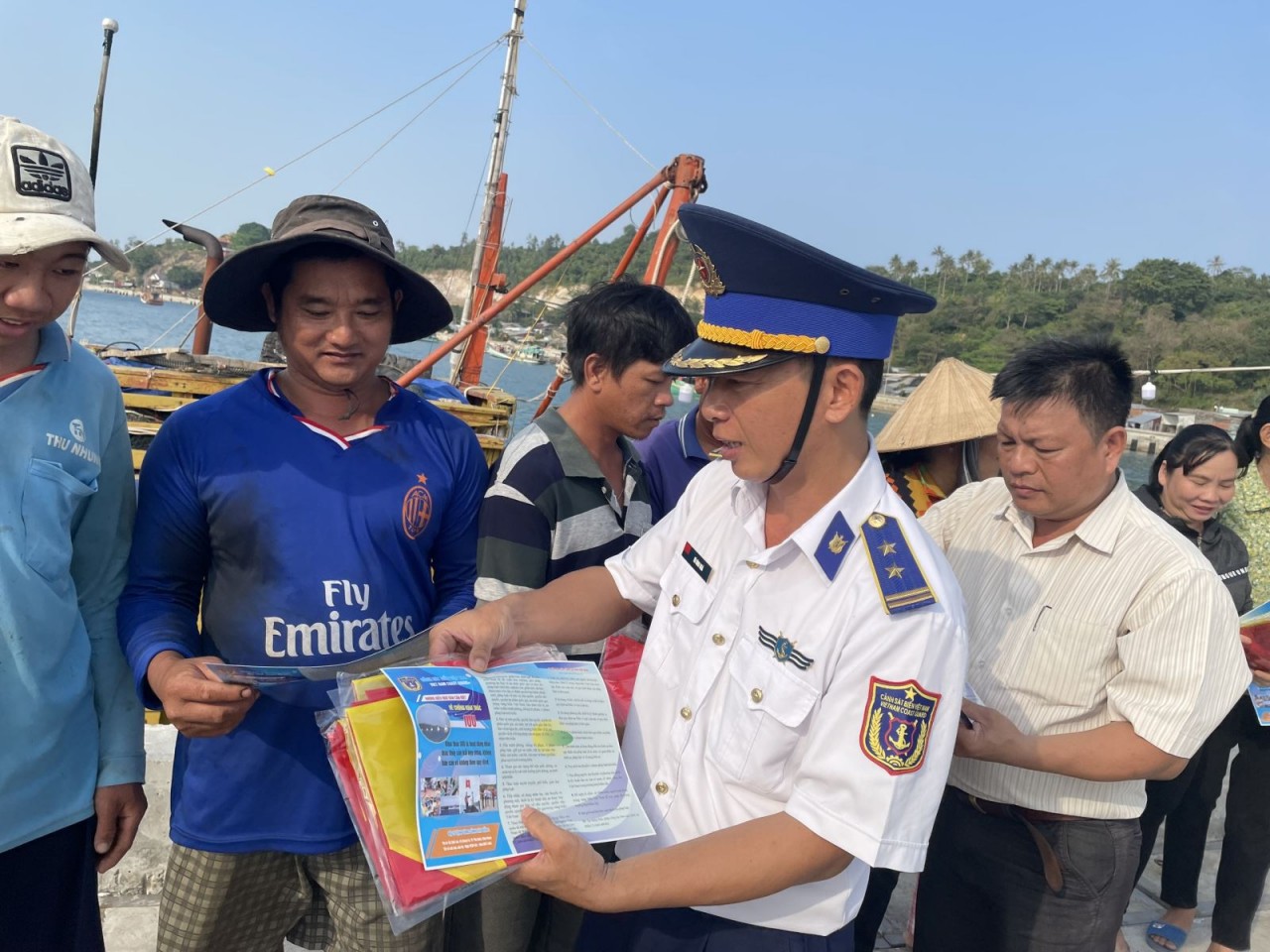 Officers of Coast Guard Region 4 distributes leaflets directly to fishermen at the fishing port. Photo: VNA