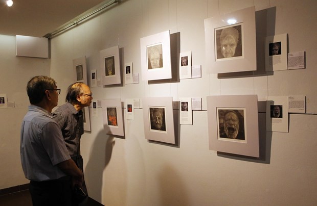 Visitors look at a painting at the exhibition in Da Nang. Photo: VNA
