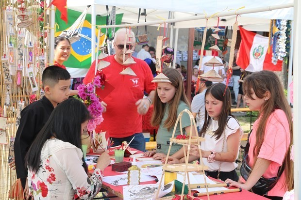 Calligraphy at the Vietnam booth attracts young people to visit and experience. Photo: VNA