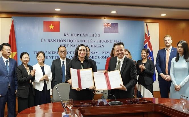 The two sides sign a document approving bilateral commitments at the meeting. Photo: VNA