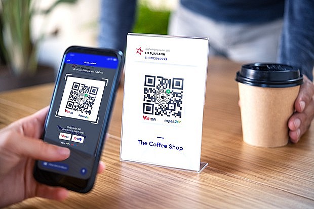 A customer pays for coffee via QR code in Hanoi. (Photo: VNA)