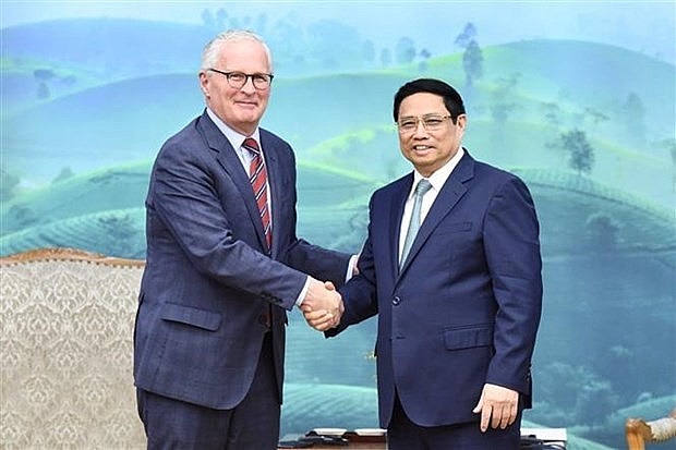 Prime Minister Pham Minh Chinh (R) and SIA President John Neuffer. (Photo: VNA)