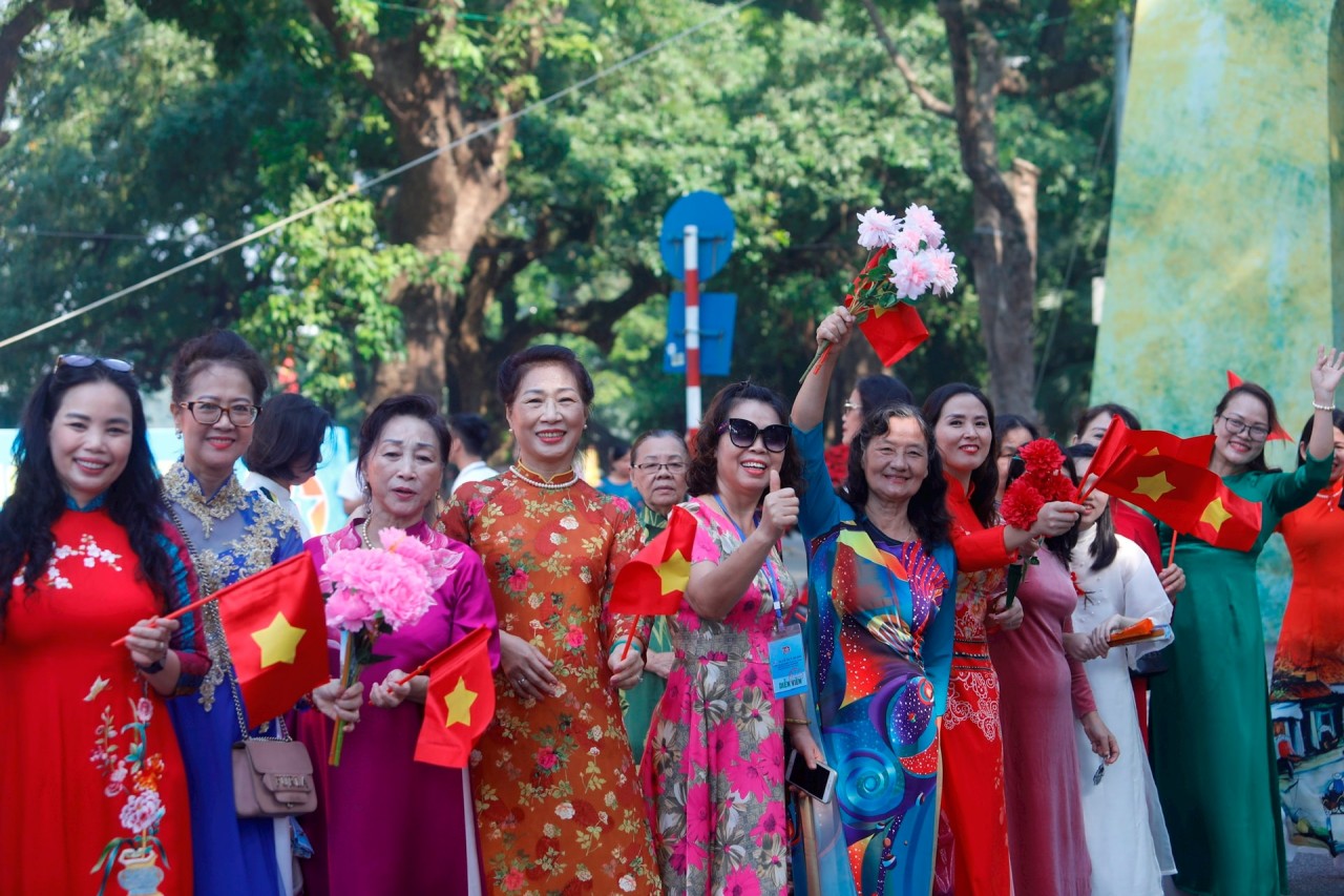 Many citizens wear traditional ao dai, waving flags and flowers, sharing their pride as they witnessed the reenactment of historical milestones in the capital during the festival. (Photo: Ha Noi Moi Newspaper) Many citizens wear traditional ao dai, waving flags and flowers, sharing their pride as they witnessed the reenactment of historical milestones in the capital during the festival. (Photo: Ha Noi Moi Newspaper)