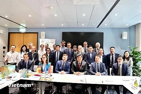 Deputy Minister Tran Thanh Nam (front line, in a red tie) takes a photo with representatives of German associations and businesses at the event. (Photo: VNA)