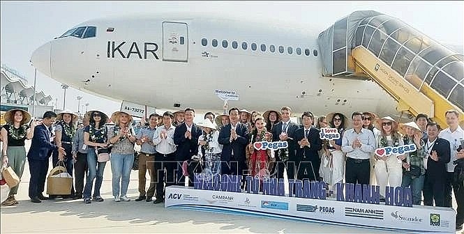 Russian tourists pose for a photo after landing at Cam Ranh International Airport, Khanh Hoa province, on April 18, 2025. (Photo: VNA)