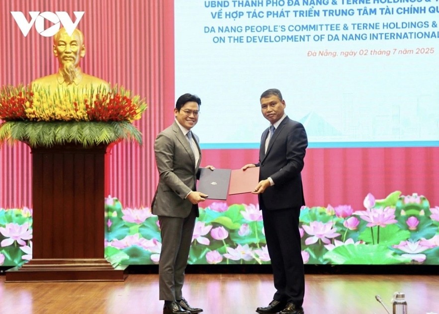 Ho Ky Minh,  Vice Chairman of the Da Nang City People's Committee (right), and Andy Khoo, CEO of Teme Holdings Pte. Ltd (Singapore), exchange the MoU on cooperation in developing an international finance center in Da Nang.