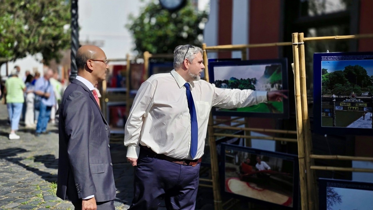 Vietnamese Ambassador to Hungary Bui Le Thai and District 3 Mayor Kiss Laszlo view a photo exhibition showcasing the land and people of Vietnam. (Photo: Vietnamese Embassy in Hungary)