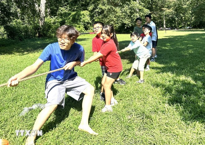 Children eagerly take part in a tug-of-war game. (Photo: Ngoc Quang/VNA) 