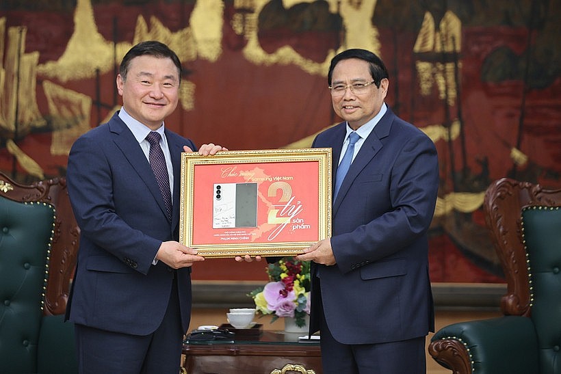 Prime Minister Pham Minh Chinh (R) and acting head of Samsung Electronics' Device Experience Division Roh Tae Moon. (Photo: VNA)