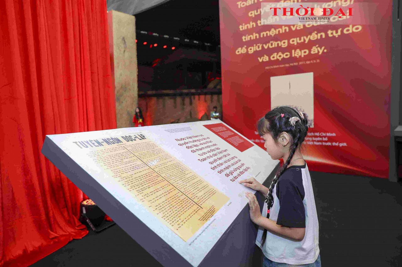 A child attentively reads the Declaration of Independence - the historic document proclaiming the birth of the Democratic Republic of Vietnam - on display at the exhibition. (Photo: Dinh Hoa)