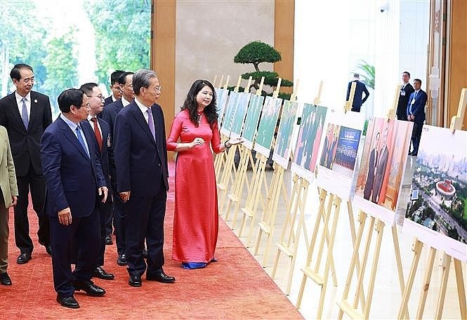 The two leaders visit a photo exhibition on Vietnam-China relations held by the Vietnam News Agency. (Photo: VNA)