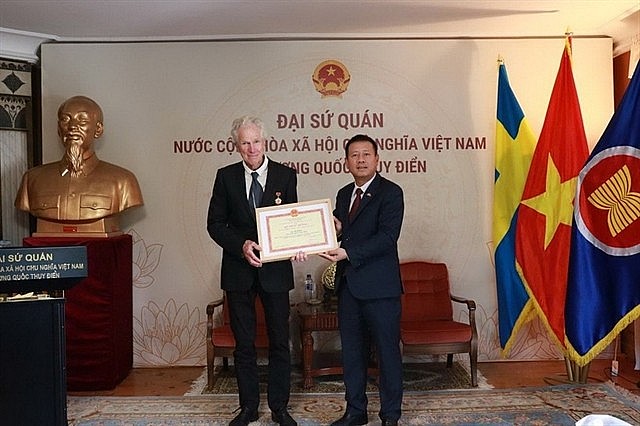 Ambassador Trần Văn Tuấn (right) presents the “For the Cause of Culture, Sports and Tourism” insignia to Swedish filmmaker Bo Öhlén. — Photo courtesy of the Embassy of Việt Nam in Sweden