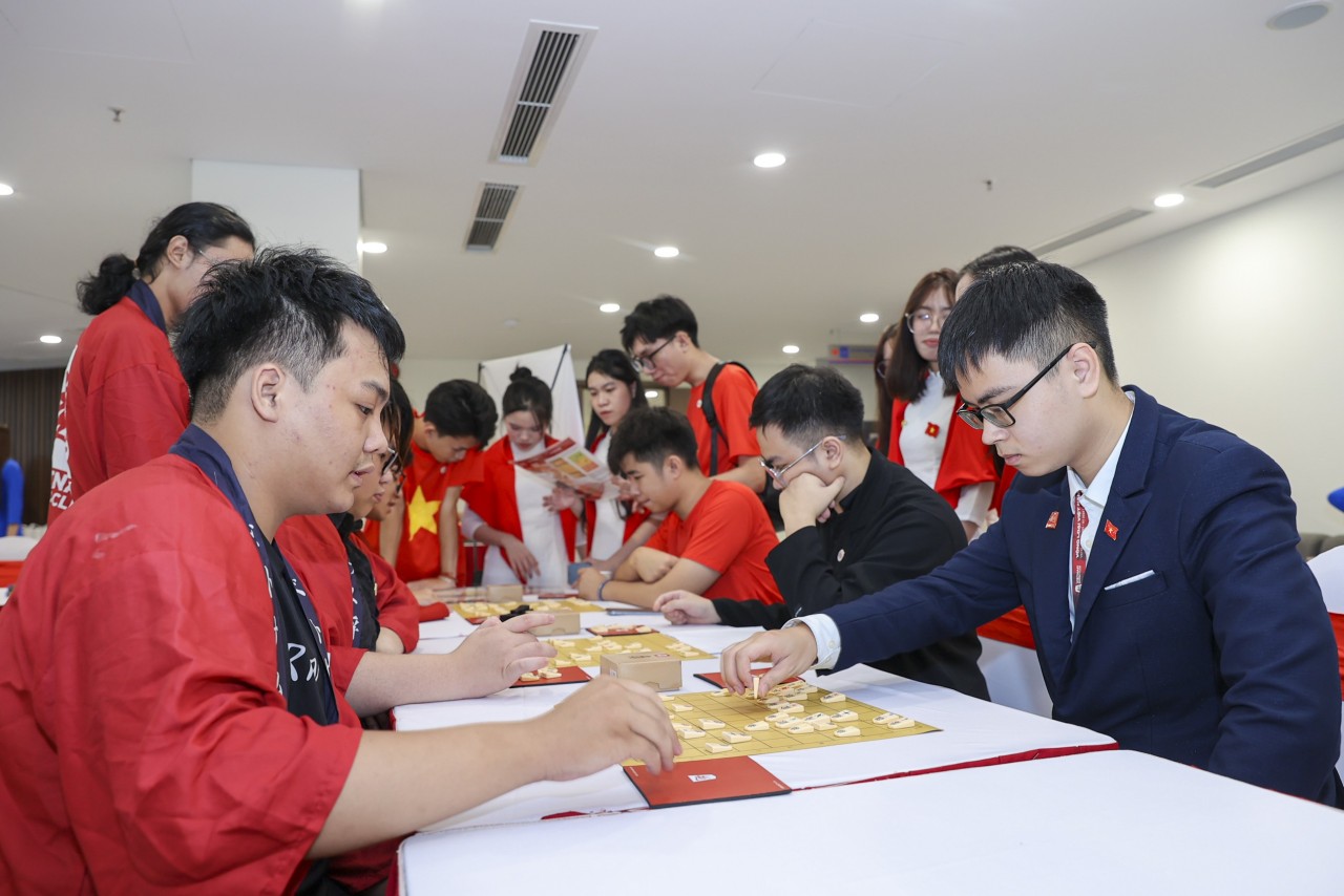 Trần Thế Trung (far right), Chairman of the Vietnam Shogi Club, guiding young people in learning about Shogi at the program. (Photo: Đinh Hòa)