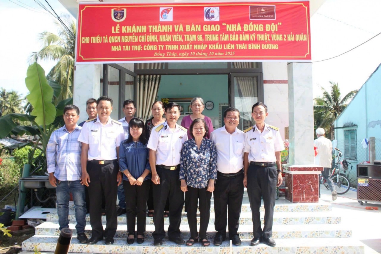 Delegates take a commemorative photo with the family of Warrant Officer Nguyen Chi Dinh.