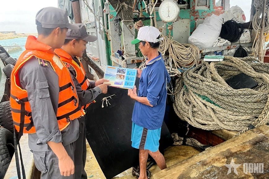 Fisheries Surveillance Team No. 4 disseminates information about IUU fishing to fishermen through leaflets. (Photo: People’s Army Newspaper)