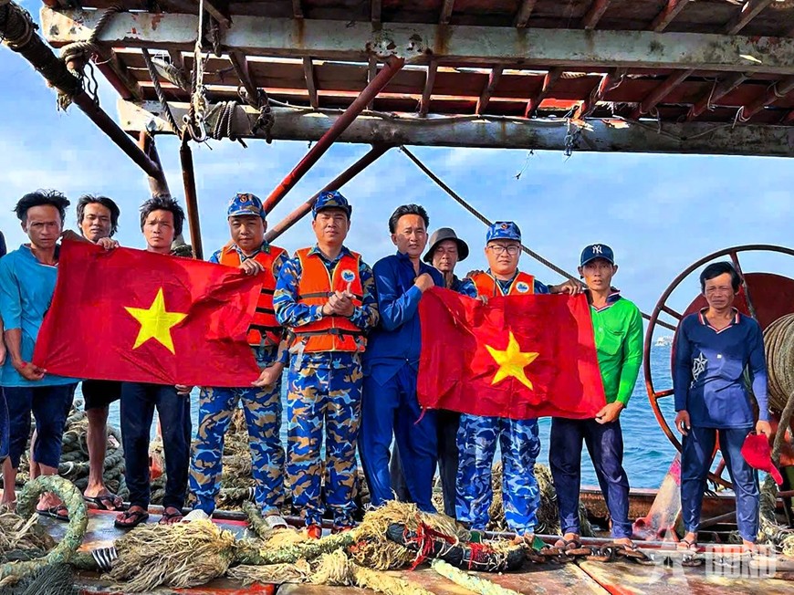 The working group of Border Guard Squadron 18 and the Command of Coast Guard Region 3 presents flags to fishermen. (Photo: People's Army Newspaper).