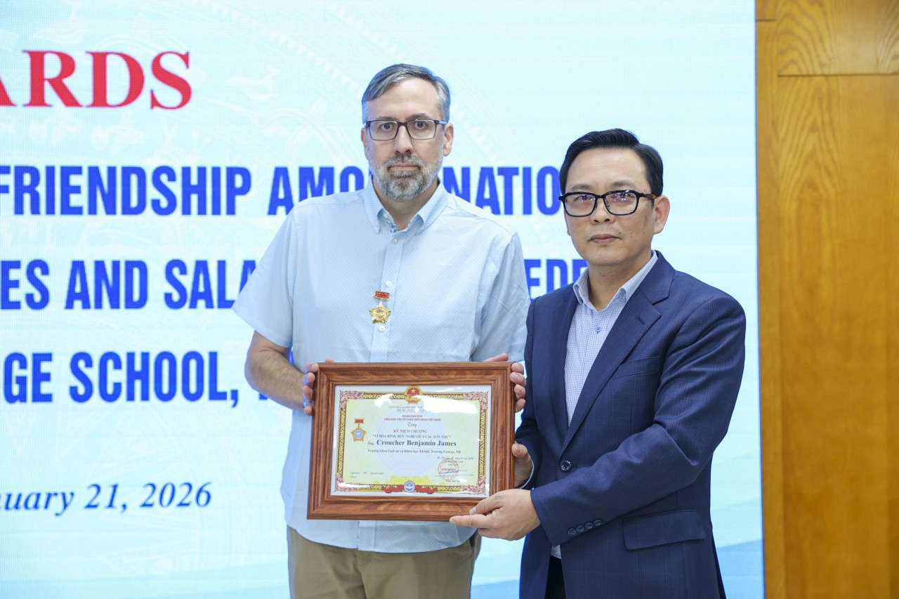 Croucher Benjamin James, Head of the Department of History and Social Sciences, George School (United States) (left), receives the Medal “For Peace and Friendship Among Nations” from the Vietnam Union of Friendship Organizations. (Photo: Dinh Hoa)