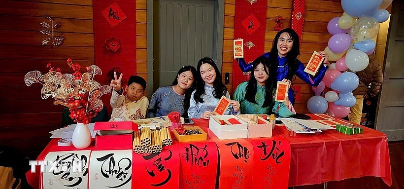 A calligraphy booth draws young Vietnamese at the gathering. (Photo: VNA)
