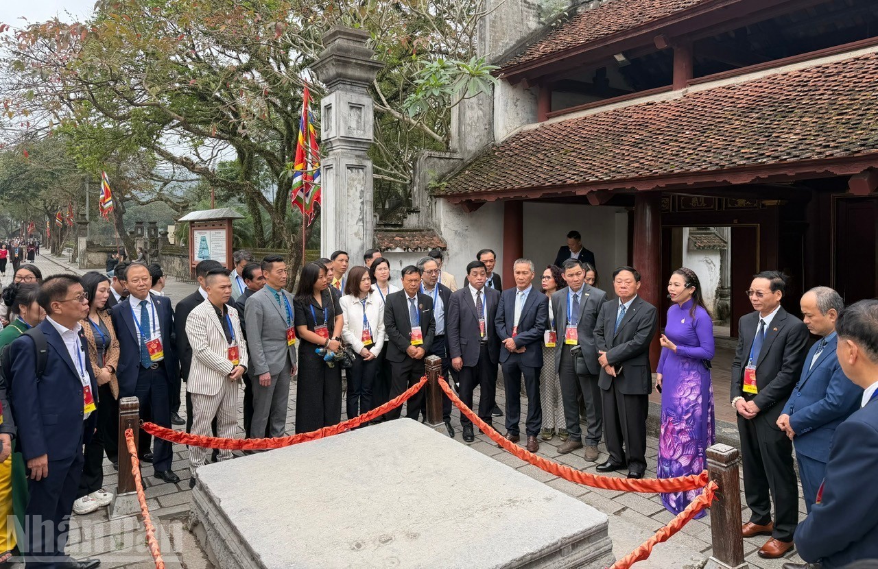 The overseas Vietnamese delegation learns about history at the Temple of King Le Dai Hanh. (Photo: People's Newspaper)