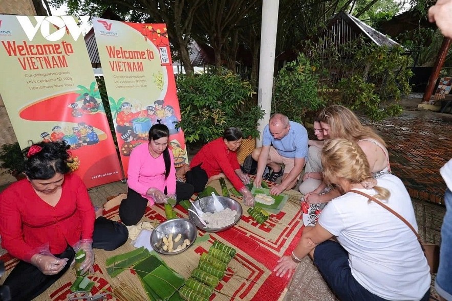 Foreign visitors enthusiastically join locals in making bánh tét for the Tet holiday Foreign visitors enthusiastically join locals in making bánh tét for the Tet holiday