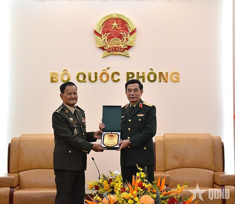 Minister of National Defence Gen. Phan Van Giang (R) hands over a gift to Secretary of State at the Cambodian Ministry of National Defence Gen. Prum Din at their meeting in Hanoi on March 9 (Photo: qdnd.vn)