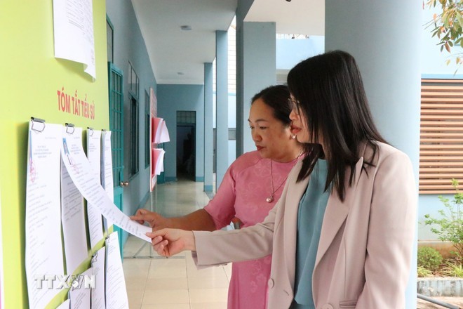 Voters in Ea Kao Ward, Đắk Lắk Province study the biographies of electoral candidates. (Photo: Nguyên Dung/VNA)