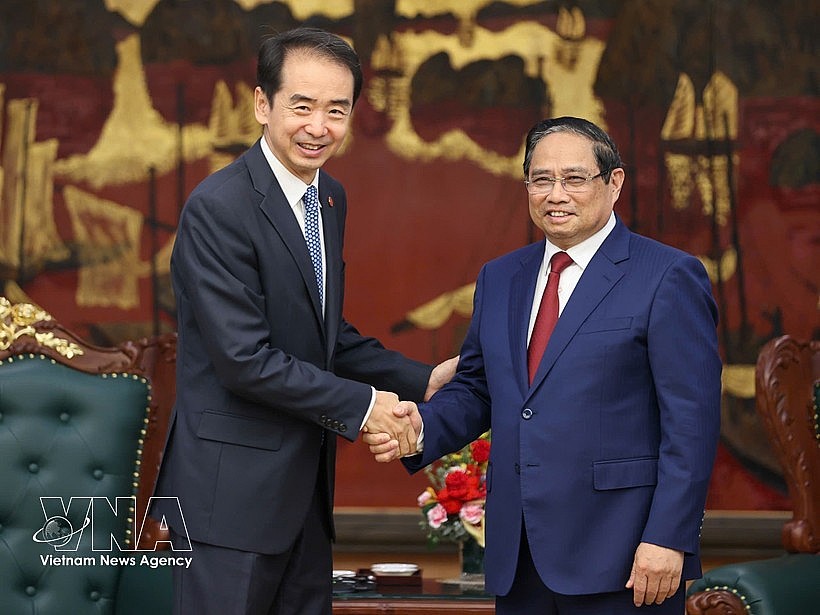 Prime Minister Pham Minh Chinh (R) hosts a reception for Chinese Ambassador to Vietnam He Wei at the Government Headquarters in Hanoi on April 5. (Photo: VNA)
