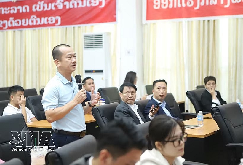 A Vietnamese business representative in Laos raises opinions at the forum. (Photo: VNA)