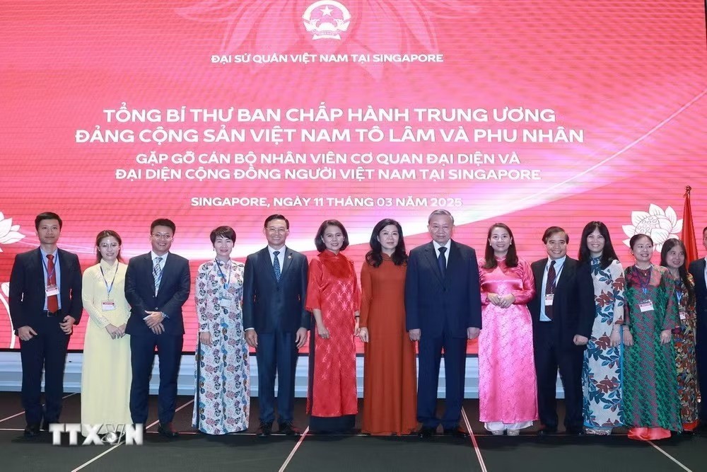 General Secretary To Lam and his spouse pose with staff of Vietnam’s representative offices and representatives of the Vietnamese community in Singapore in March 2025. (Photo: Thong Nhat/VNA) General Secretary To Lam and his spouse pose with staff of Vietnam’s representative offices and representatives of the Vietnamese community in Singapore in March 2025. (Photo: Thong Nhat/VNA)
