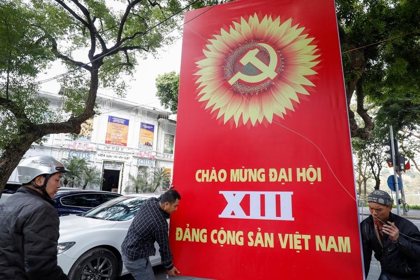  Workers set up a poster for upcoming 13th National Congress of the ruling Communist Party of Vietnam, on a street in Hanoi, Vietnam January 12, 2021. 