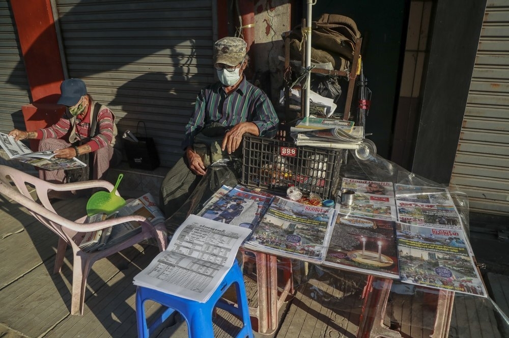 One man reading newspaper at a newsstand in yangon, myanmar on february 2 (photo: ap) 