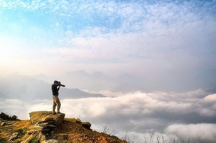 A visitor taking photos of the cloud sea underneath