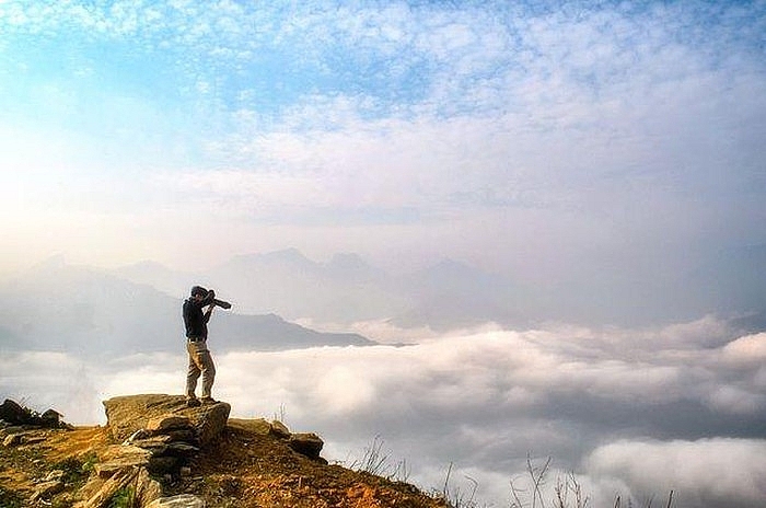 Top Vietnam Destinations: Year-round magical beauty of Y Ty - the northern highland A visitor taking photos of the cloud sea underneath