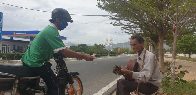 Blind beggar asking for money almost 60 years to raise 6 children A passer-by giving Minh some money