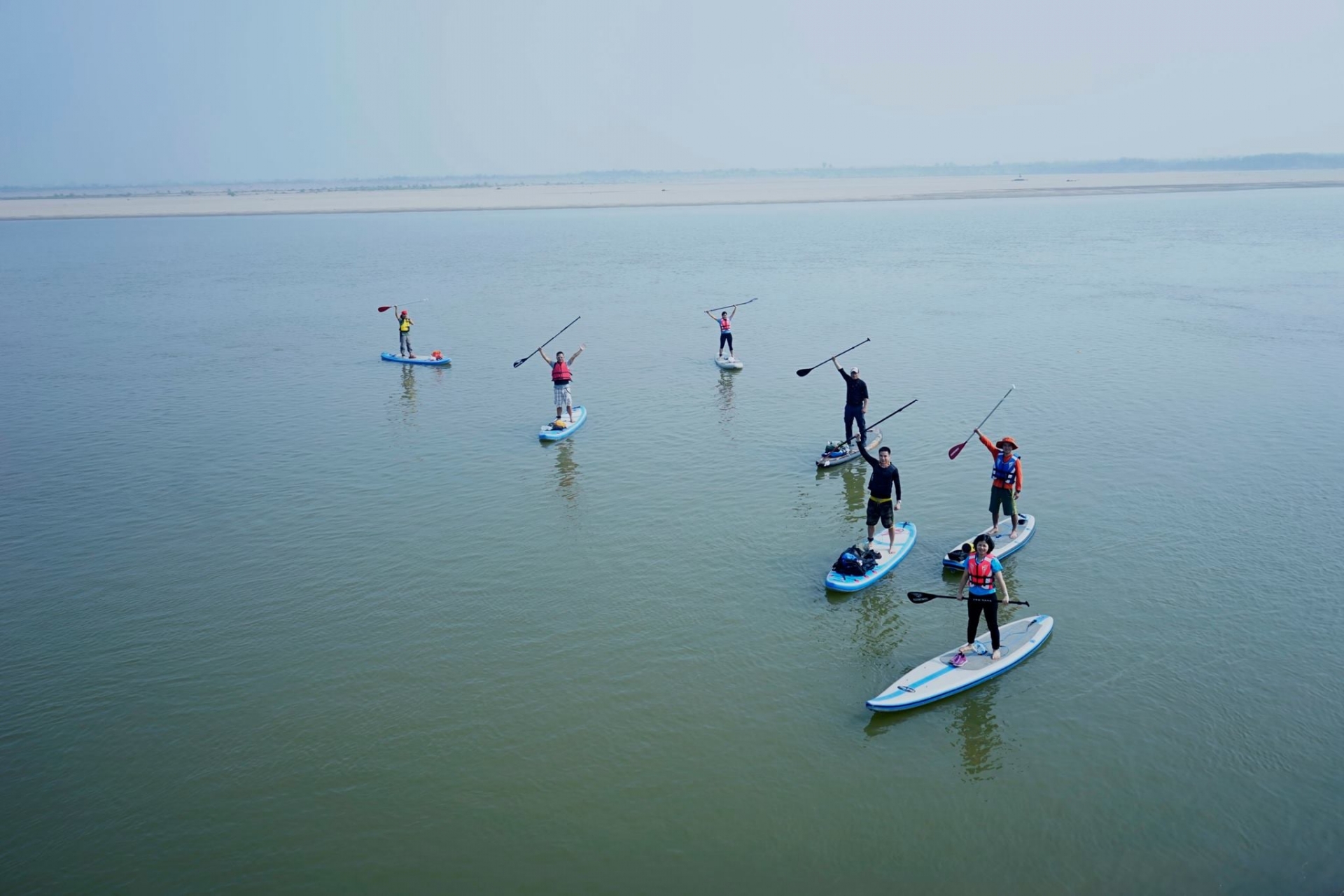 Young people in Hanoi try paddle boarding on Red river
