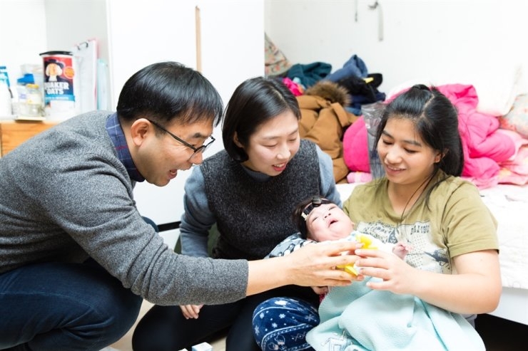 Cheong Jong-won, a pastor, and his wife Kim Sung-eun visit a woman and her baby at her home in Seoul in this March 2018 photo. Courtesy of Light and Salt
