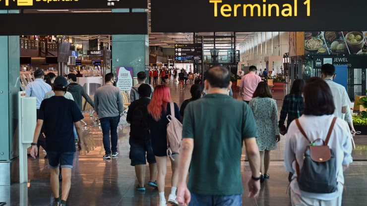 People walk toward the departure hall at Changi International Airport in Singapore on March 15, 2021. Roslan Rahman | AFP | Getty Images