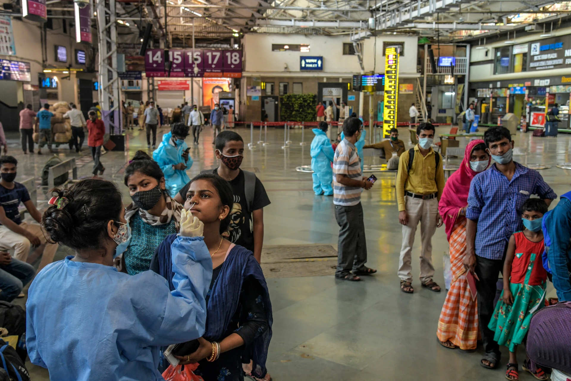 Health workers testing recent arrivals at a train station in Mumbai earlier this month. (Photo: New York Times)