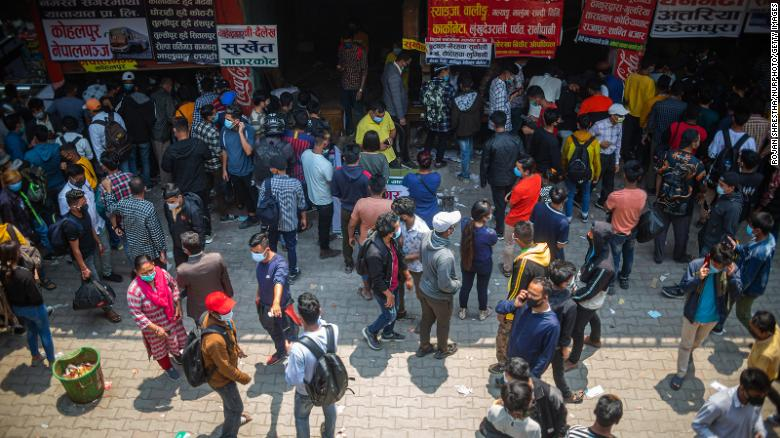People wait to board a bus back to their home villages after new government restrictions in Kathmandu, Nepal, on April 27. (Photo: CNN) 