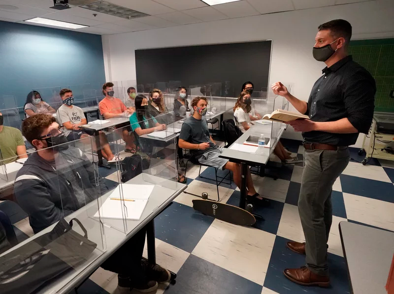 The CDC announced Thursday that fully vaccinated people can safely stop wearing masks indoors and outdoors. Kyle Faircloth teaches a class at Palm Beach Atlantic University in West Palm Beach, Fla., in February. Wilfredo Lee/AP