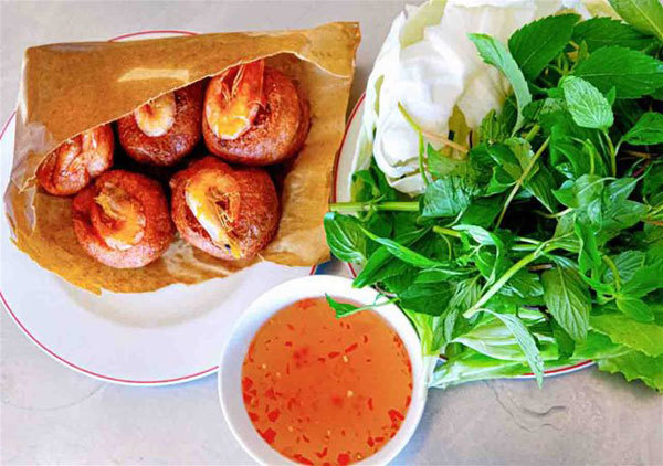 Fried shrimp cakes are served with lettuce, herbs and sweet and sour fish sauce. (Photo: Vietnamnet) 