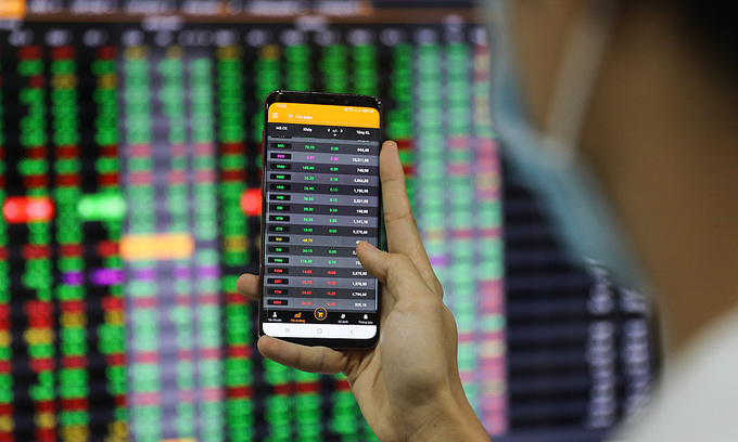An investor looks at stock prices on a smartphone at a brokerage in HCMC's District 1, January 2020. Photo by VnExpress/Quynh Tran