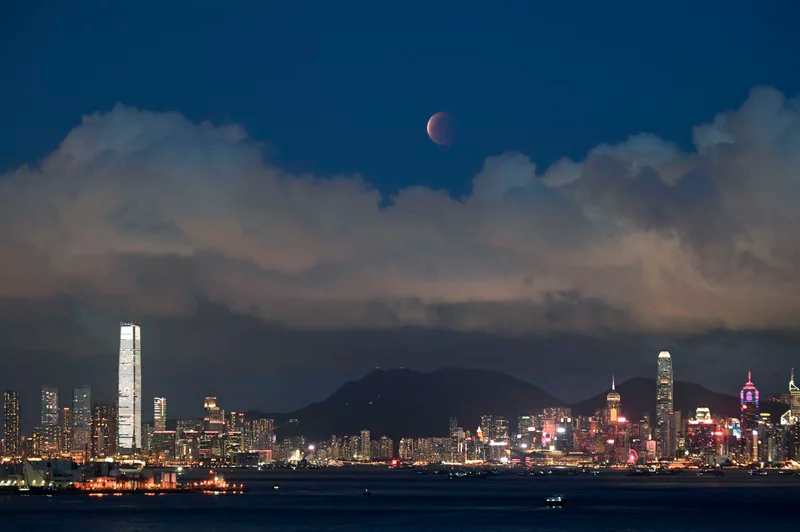 The moon rises over Victoria Harbour in Hong Kong on Wednesday. Kin Cheung/AP