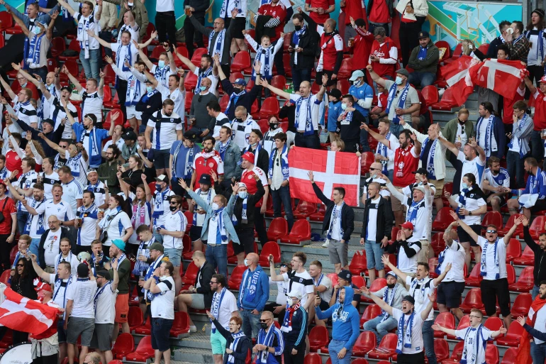 Finland and Denmark fans cheer the name of Denmark's Christian Eriksen inside the stadium after the match is postponed [Wolfgang Rattay/Reuters]