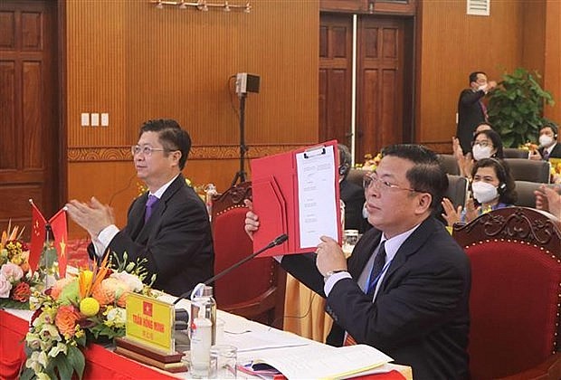 Secretary of Cao Bang's Party Committee Tran Hong Minh (R) signs memorandum of understanding on friendship cooperation (Photo: VNA)