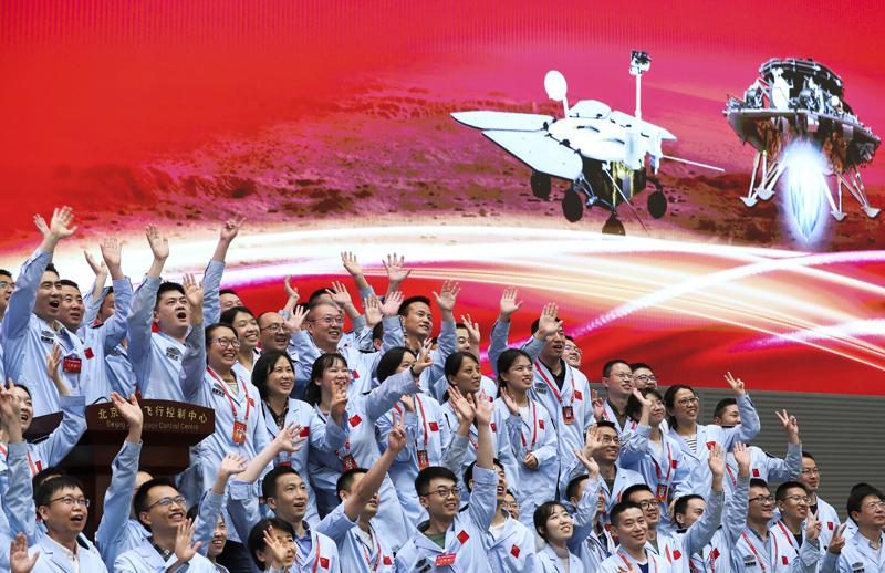 In this photo released by Xinhua News Agency, members at the Beijing Aerospace Control Center celebrate after China's Tianwen-1 probe successfully landed on Mars, at the center in Beijing, Saturday, May 15, 2021. China landed a spacecraft on Mars for the first time on Saturday, a technically challenging feat more difficult than a moon landing, in the latest advance for its ambitious goals in space. (Jin Liwang/Xinhua via AP)
