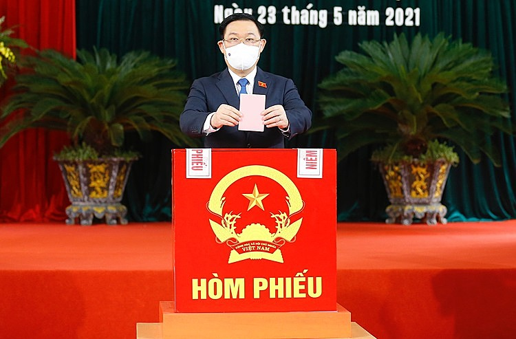 National Assembly chairman Vuong Dinh Hue casts his votes into a ballot box at a polling station in Hai Phong.