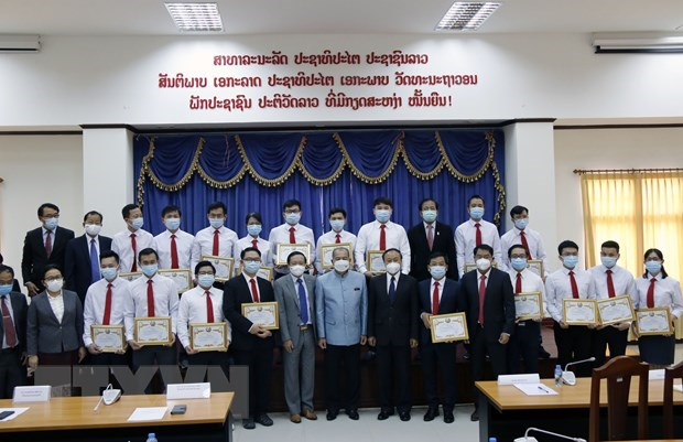 Lao Deputy Prime Minister Kikeo Khaykhamphithoune (centre) and officials pose for a group photo with Vietnamese medical experts. (Photo: VNA)