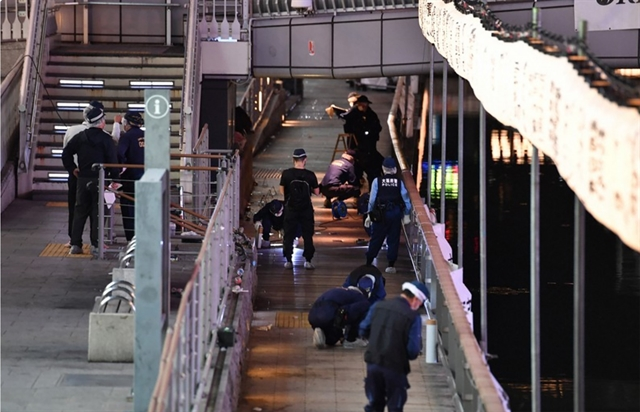 Police in Osaka, Japan examine a bridge in the Namba Parks area where a Vietnamese student was pushed into the Dotonbori River underneath and died on Monday. — Mainichi/VNA Photo