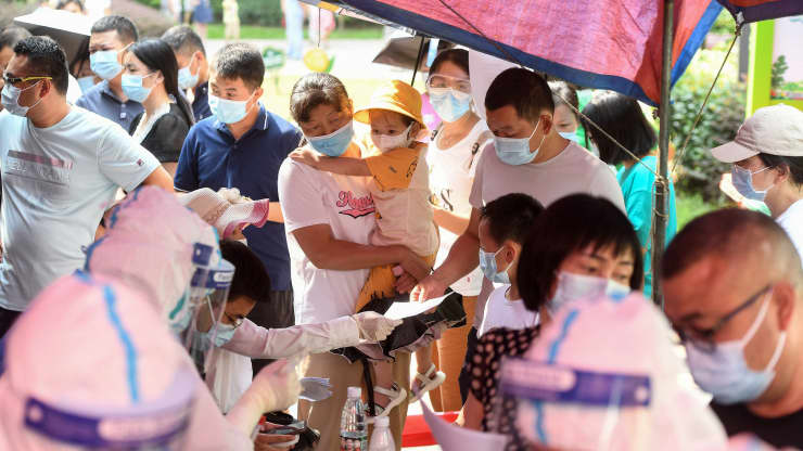 Residents of Wuhan city in China’s Hubei province queue to take nucleic acid tests for Covid-19 on August 3, 2021. STR | AFP | Getty Images